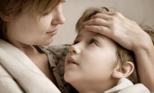 En mor holder sit barn tæt ind til sig, da det er normalt for forældre at beskytte sine børn