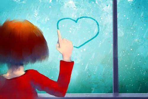 En pige, der tegner et hjerte på et vindue