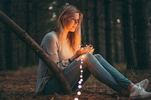 en pige med lys i en skov