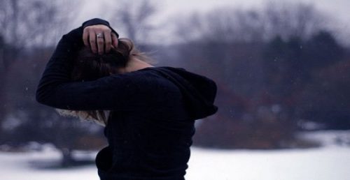 Kvinde med hoved gemt under arme oplever følelsesmæssig ræsonnement