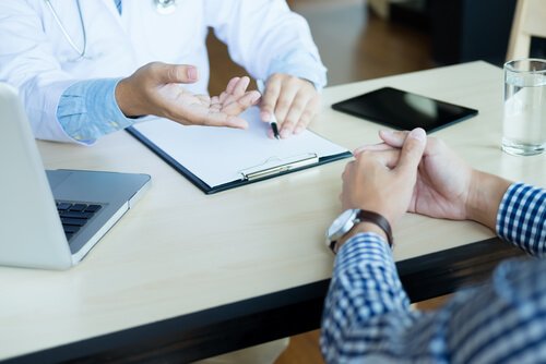 Patient diskuterer med læge over bord