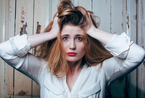 En stresset kvinde river sig i håret