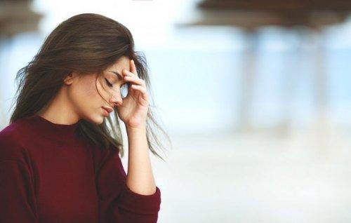 Kvinde tager sig til hoved