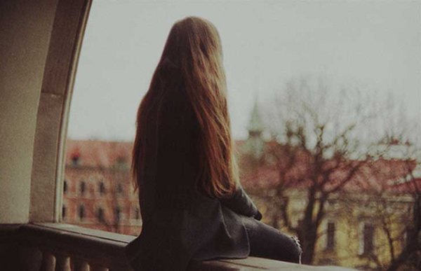 Kvinde sidder på balkon og føler sig ensom alene