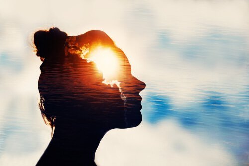 Silhuet af kvinde med lys i panden som symbol for mentale øvelser til lykke