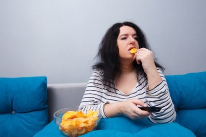 Kvinde, der spiser chips, fører stillesiddende livsstil