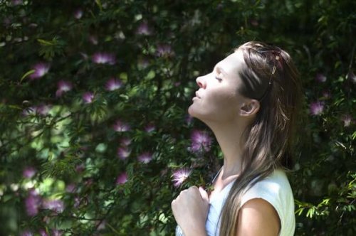 Kvinde trækker vejret intenst foran blomster