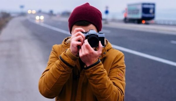 mand tager fotos på vej