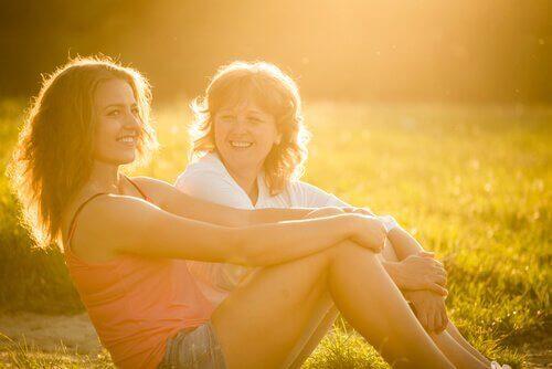 Mor og datter på eng i sollys