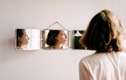 Kvinde kigger på sig selv i spejlet