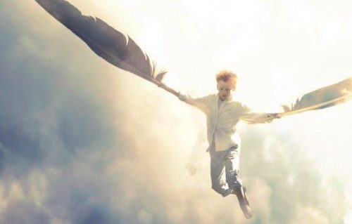 Dreng svæver med fjer som vinger