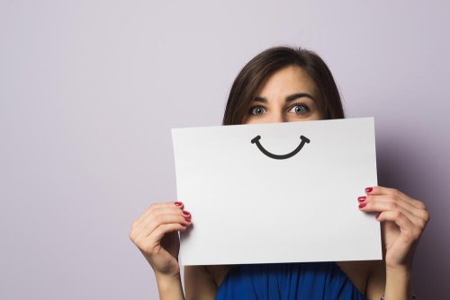 Kvinde med smil på papir anvender et positivt sprog til at blive glad