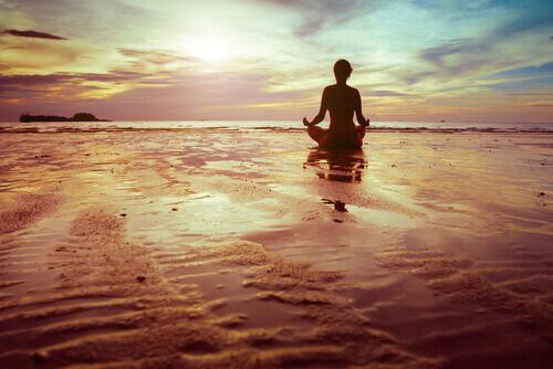 kvinde mediterer på strand