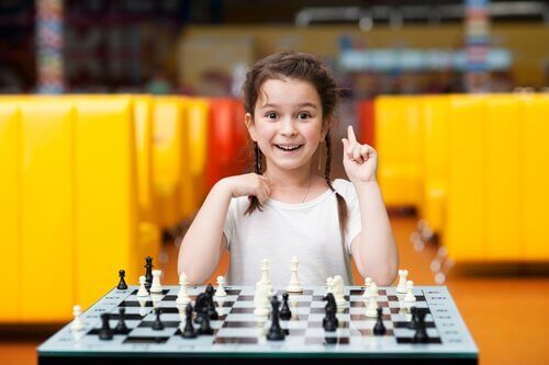 En smilende pige spiller skak