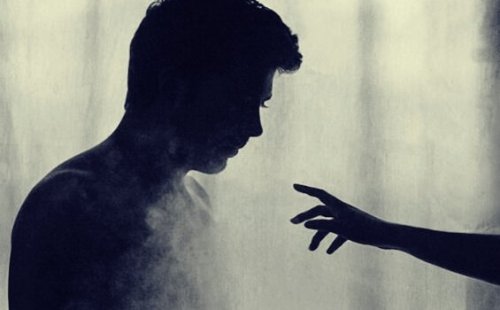 En hånd nærmer sig silhuetten af en mand