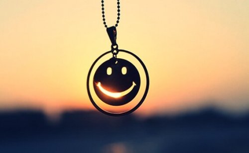 Smiley i halskæde foran sol