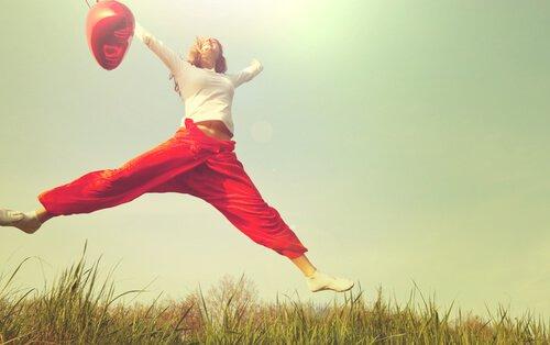 Kvinde hopper med rød ballon