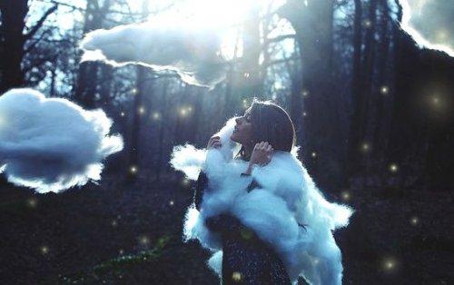 Kvinde omringet af skyer i skov