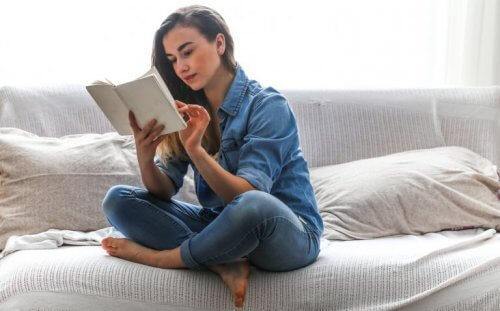 En kvinde sidder og læser på sengen