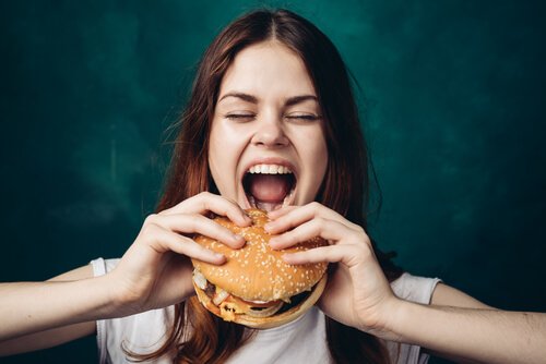 Kvinde med stor burger illustrerer sult forårsaget af angst