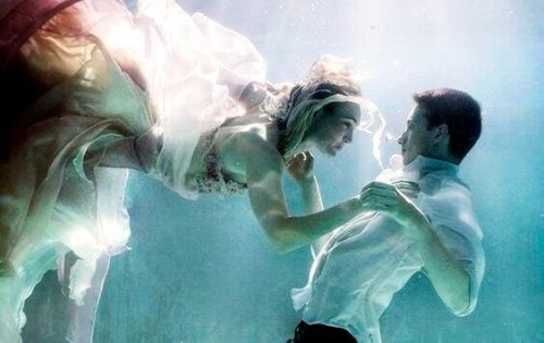 Et par holder hinanden i hånden under vandet
