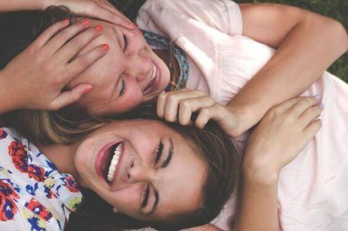 To leende teenagere med hovederne sammen