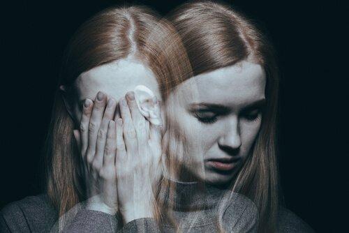 Kvinde skjuler ansigt i hænder for at udtrykke traumer