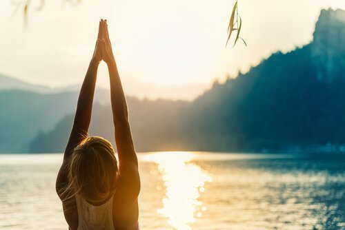 Kvinde laver yogaøvelser ved sø