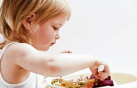Pige spiser med hænderne
