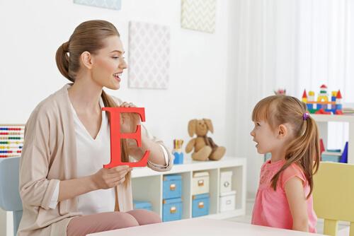 Pige lærer bogstaver med sin mor