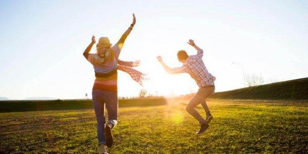 Personer danser i solen på eng