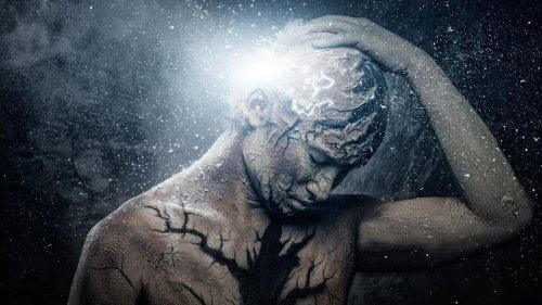 Person, der tager sig til hoved, omgivet af lys og stjerner