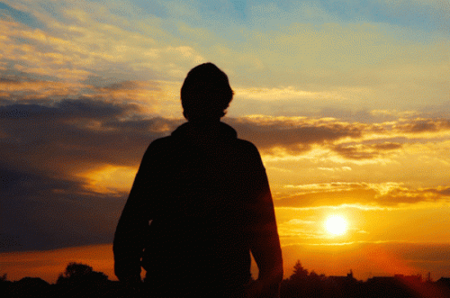 Persons silhuet foran solnedgang