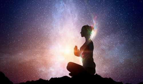 En kvinde mediterer under en stjernehimmel