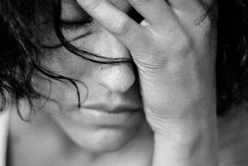 Kvinde, der tager sig til hoved, oplever tusmørketilstand