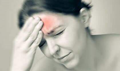 Kvinde med smerte i panden illustrerer migræne