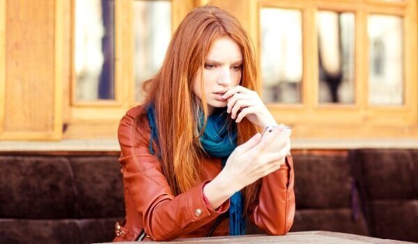 kvinde ser bekymret på sin telefon