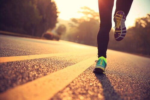 Person, der løber på vej, nyder, at fysisk træning giver velvære