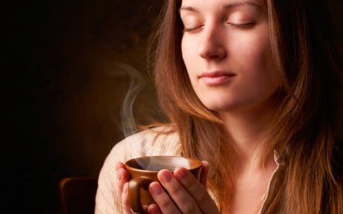 Kvinde med lukkede øjne nyder, at kaffe er stimulerende