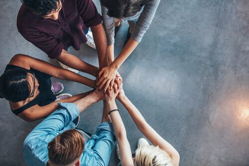 Gruppe af mennesker står med hænder samlet