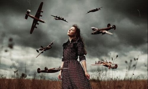 En kvinde står i et felt med en stormfulde himmel bag hende, omgivet af flyvende miniaturefly.