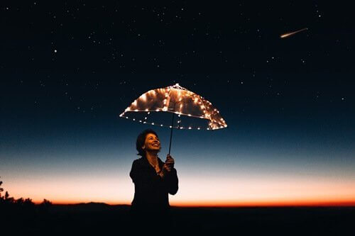 Kvinde under paraply af lyskæder