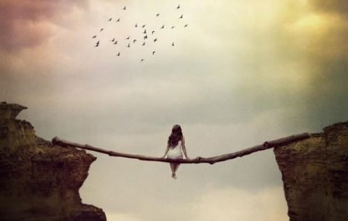 En kvinde sidder på en gren over en afgrund