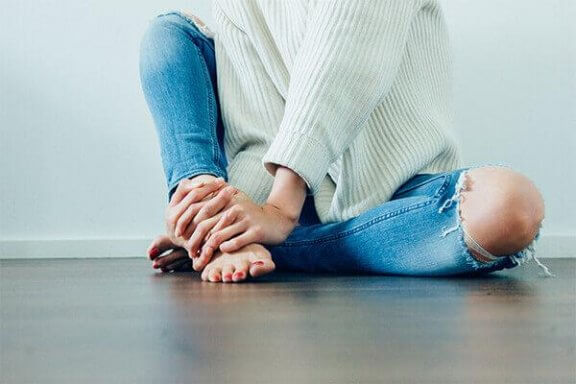 En kvinde sidder på gulvet