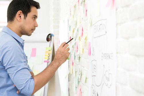 En mand ser på noter på et whiteboard