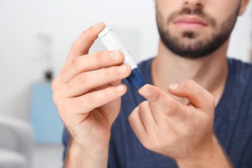 En mand med diabetes kontrollerer sit blodsukker