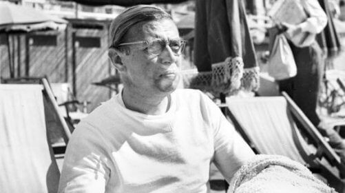 Jean-Paul Sartre sidder i en strandstol