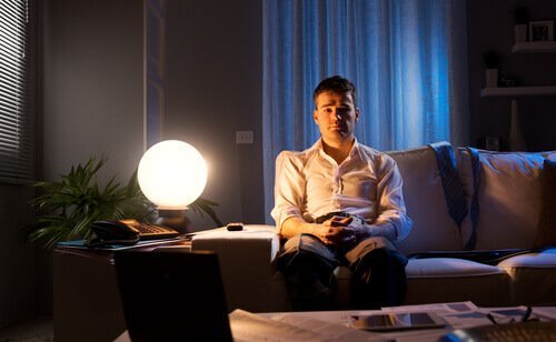 Mand i sofa om natten lider af stressrelateret søvnløshed