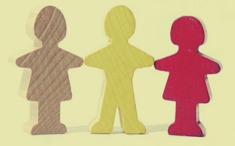 Tre papirdukkefigurer holder hinanden i hænderne