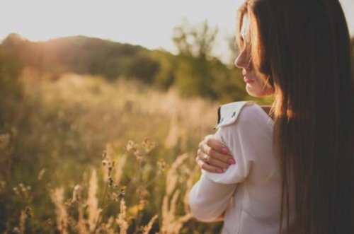 Kvinde krammer sig selv på mark, da det er vigtigt, at danne et venskab med dig selv